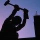 Construction worker using sledgehammer, silhouette