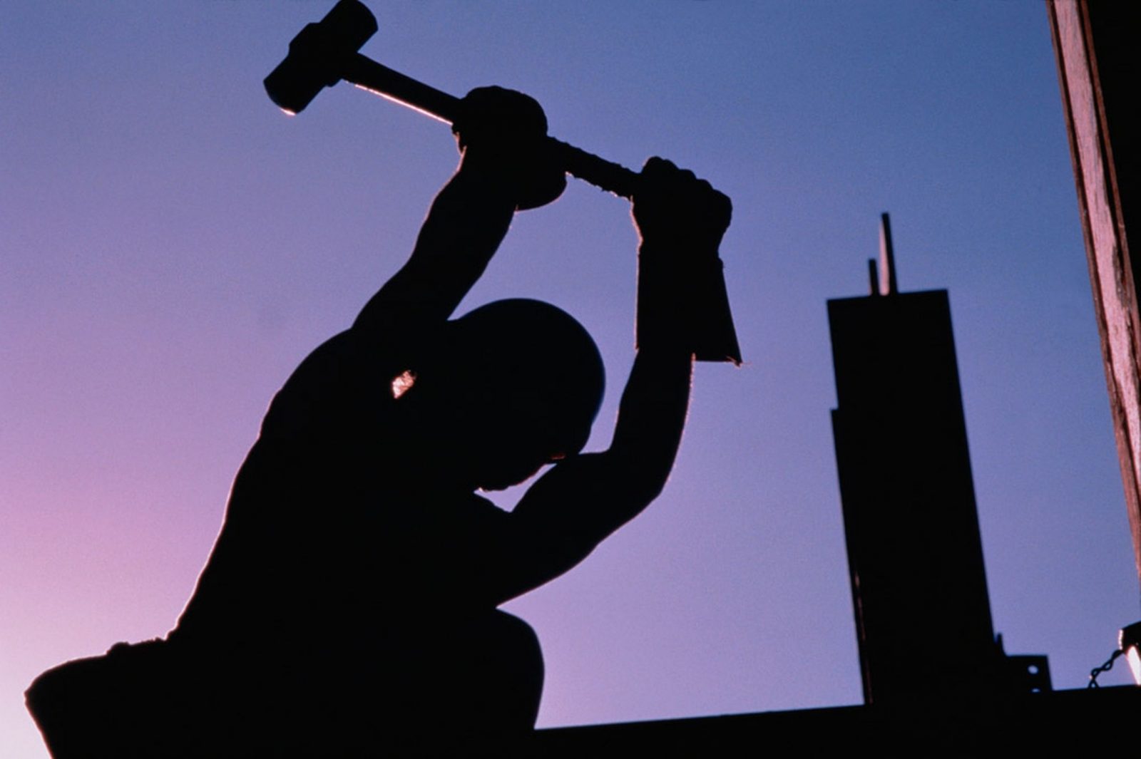 Construction worker using sledgehammer, silhouette